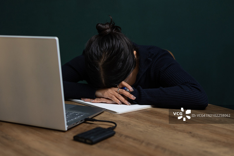 使用笔记本电脑并表达情感的棕发年轻女子图片素材
