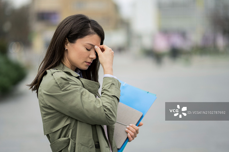 工作过度的女人在上班途中头痛图片素材