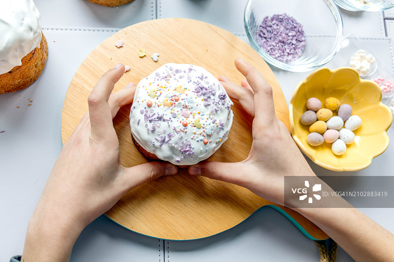 手拿复活节蛋糕，饰有糖兔子和糖屑图片素材