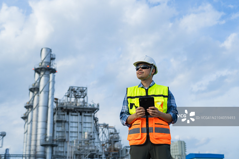 工业工程师在电厂重工业背景下查看平板电脑数据图片素材