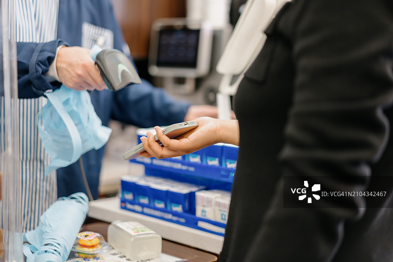 女人在商店用手机支付图片素材