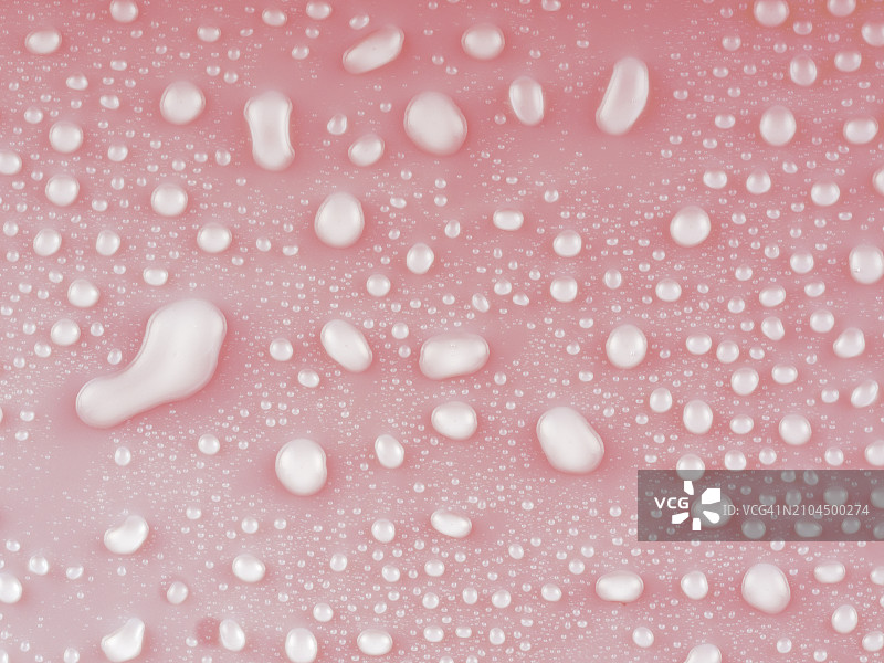 柔和粉色背景上的水滴和水花特写图片素材