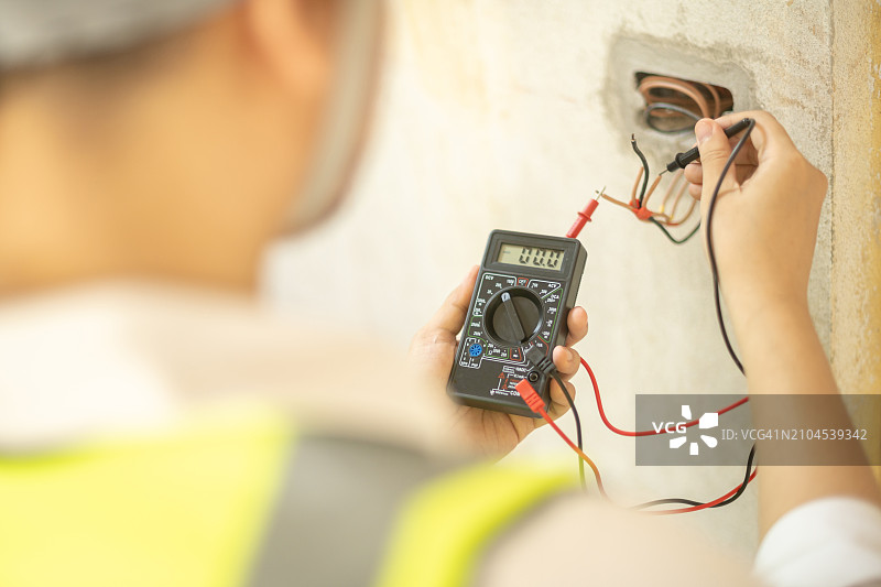 电气工程师测量新装修房屋中新安装插座的电流图片素材