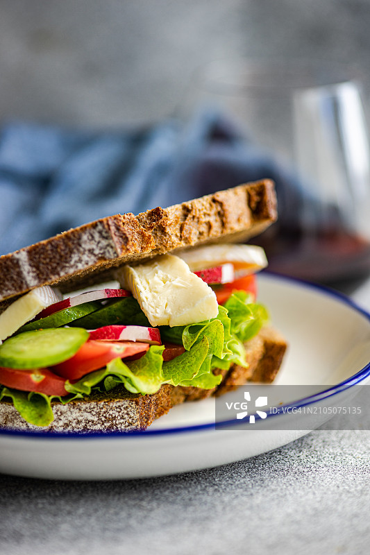 黑麦面包三明治特写，配生菜、番茄、黄瓜、小萝卜和布里奶酪图片素材