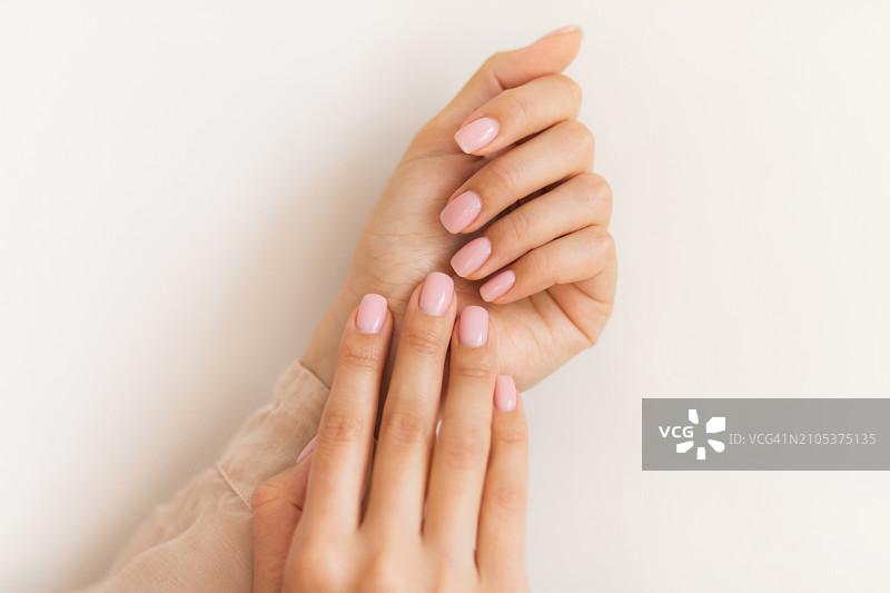 涂浅粉色指甲油的女性手部美甲图片素材