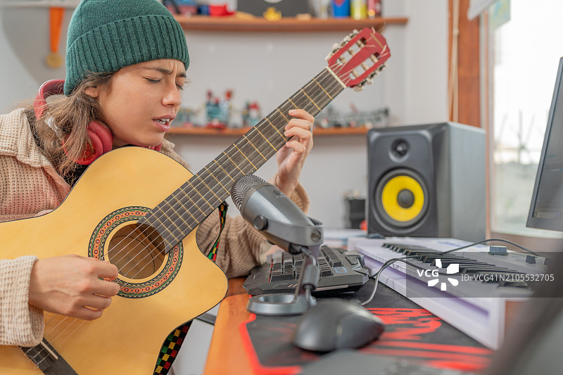 在音乐工作室里弹吉他唱歌的女人图片素材