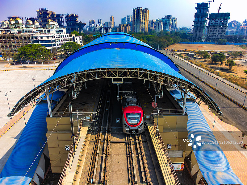 印度孟买卡尔加尔火车站城市轨道交通/高架地铁列车到站和离站的无人机拍摄图片素材