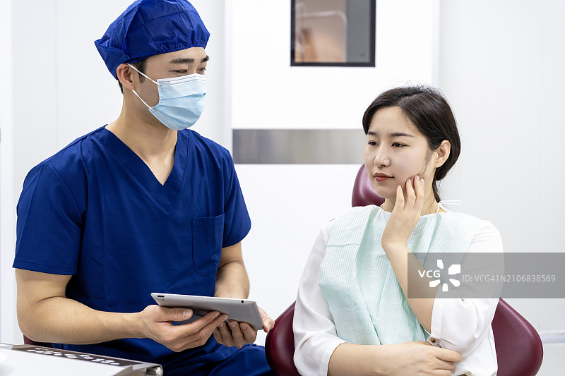 牙医在诊所通过平板电脑向患者讲解图片素材