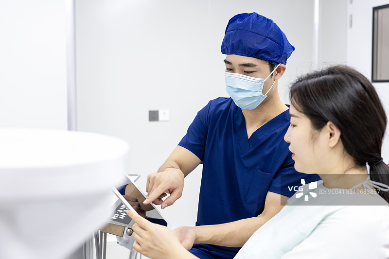 牙医在诊所通过平板电脑向患者讲解图片素材