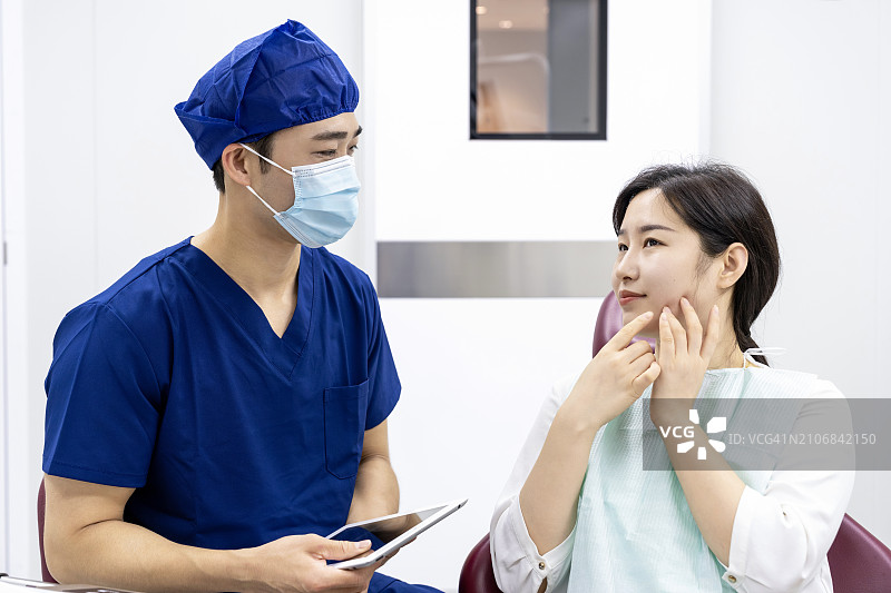 牙医在诊所通过平板电脑向患者讲解图片素材