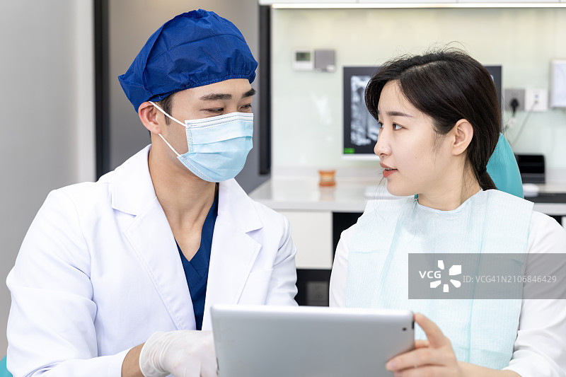 牙医在诊所通过平板电脑向患者讲解图片素材