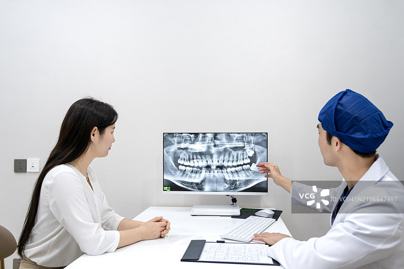 牙医和患者在牙科诊所办公室讨论牙齿治疗计划图片素材