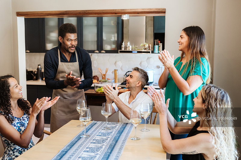 朋友为在现代厨房做饭的男人鼓掌图片素材
