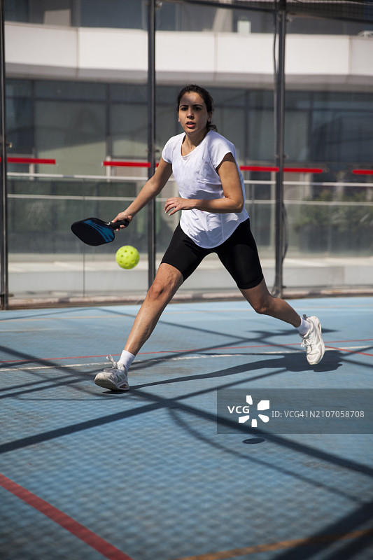 年轻女子在比赛中专注地击打匹克球图片素材