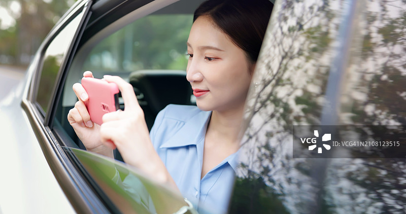 女人坐在出租车上使用手机图片素材