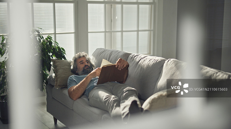 中年男人在家阅读书籍图片素材