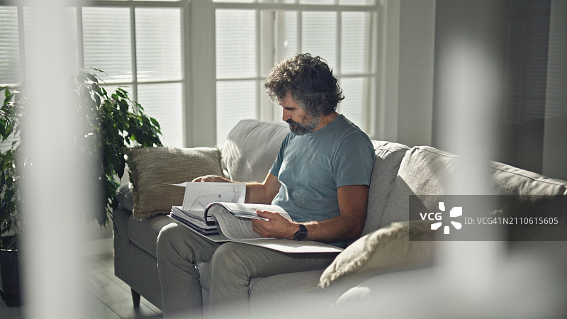 中年男人在家中查阅文件图片素材