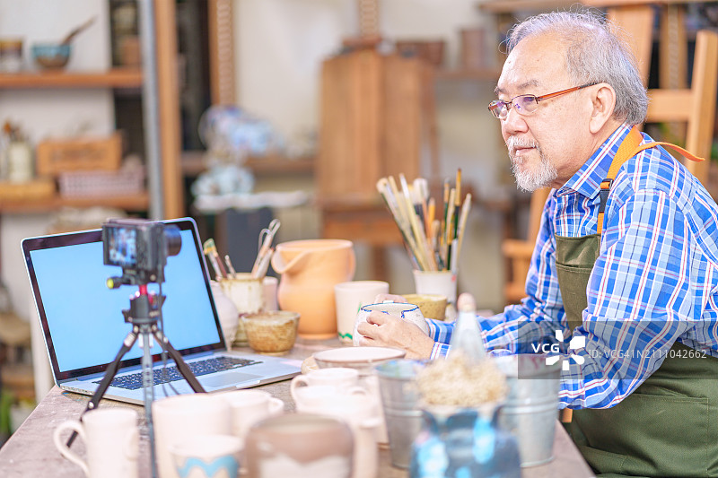 工匠在陶艺工作室拍摄手工黏土制品，用于线上商店图片素材