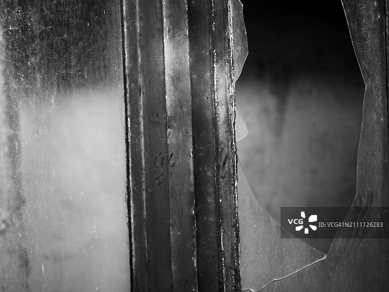 窗户破玻璃的特写。在法国巴黎一栋废弃房屋的户外拍摄。阳光。图片素材