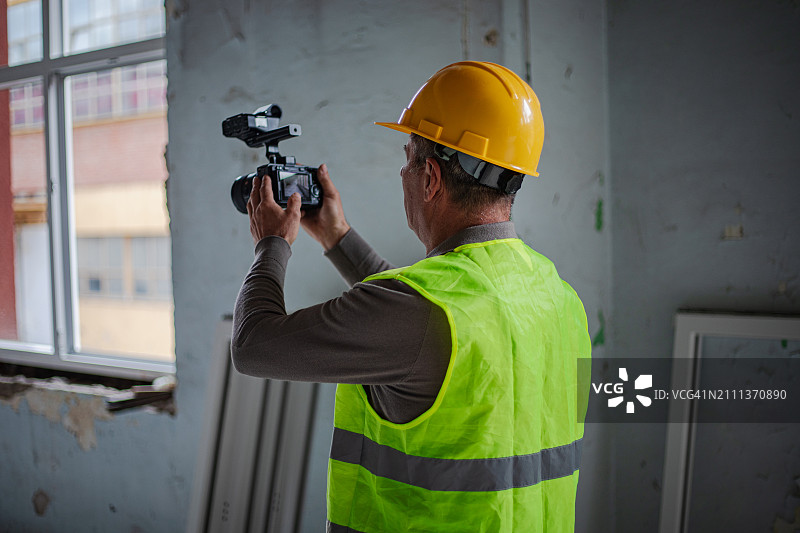 摄影师拿着相机在建筑工地图片素材