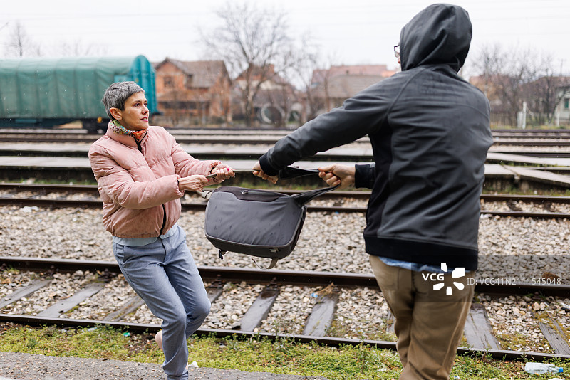 中年妇女正在与小偷争夺她的财产图片素材