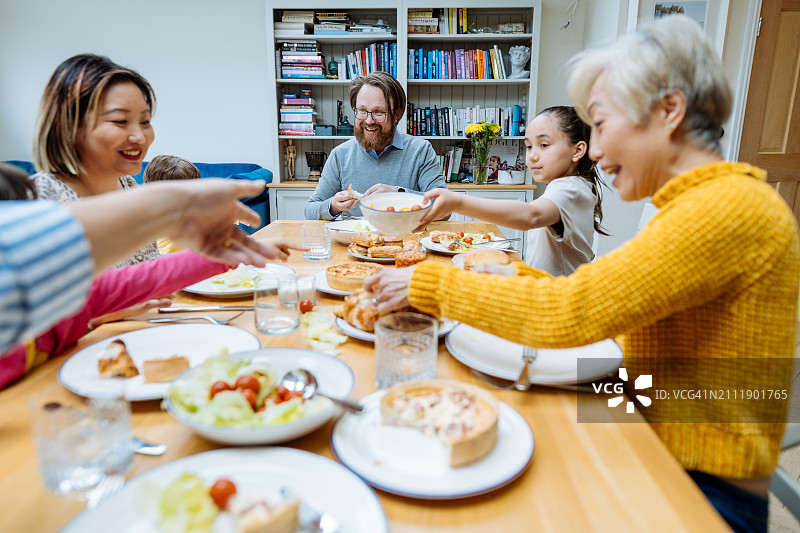 多代同堂家庭在家共进午餐。年长的中国家庭成员与孩子们一起享用周日午餐图片素材