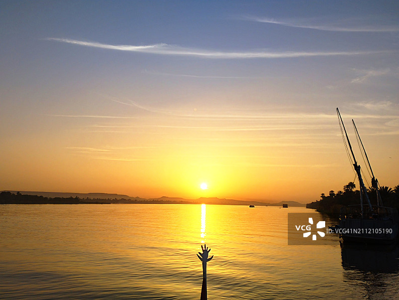 埃及阿斯旺省埃德福日落时海中帆船的轮廓图片素材