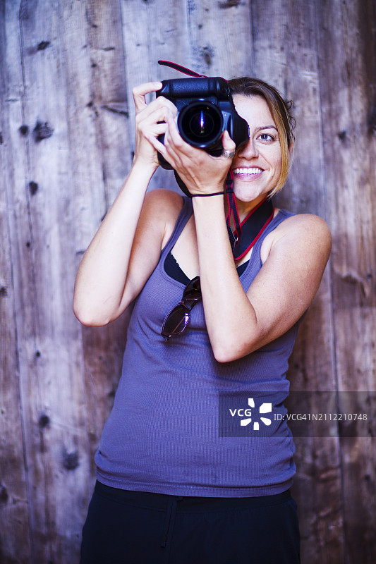 笑容满面站在相机后的女摄影师图片素材