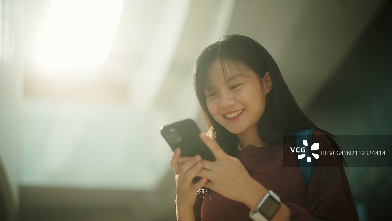 亚洲青少年在建筑内使用智能手机图片素材