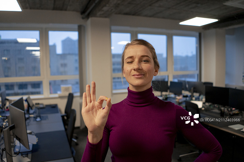 在办公室做出OK手势的年轻女商人图片素材