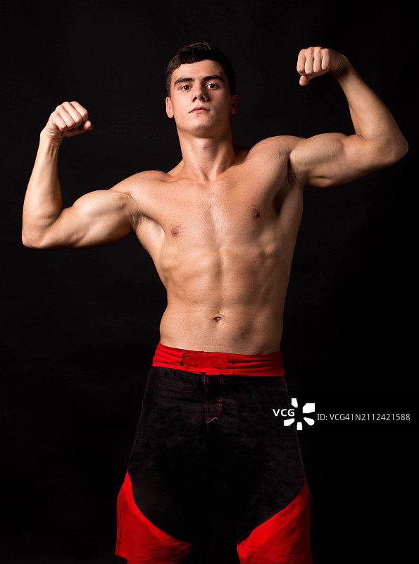 赤膊年轻男子黑色背景肌肉展示肖像图片素材