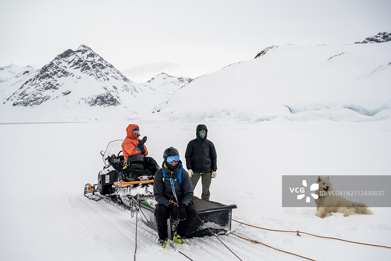 朋友和狗在冰面上驻足等待图片素材