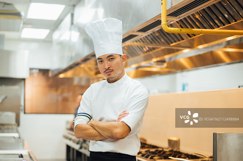 专业烹饪学校厨房里的亚洲男厨师肖像图片素材