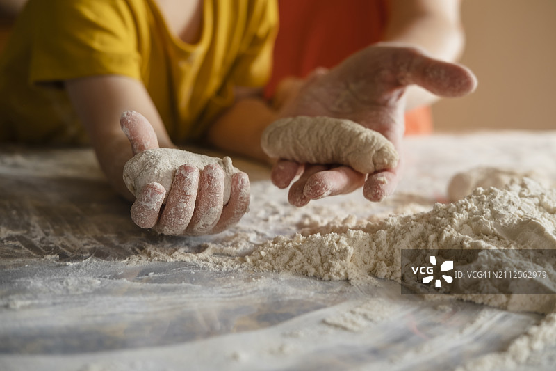 孙子和祖母在家中厨房拿着面团包子图片素材