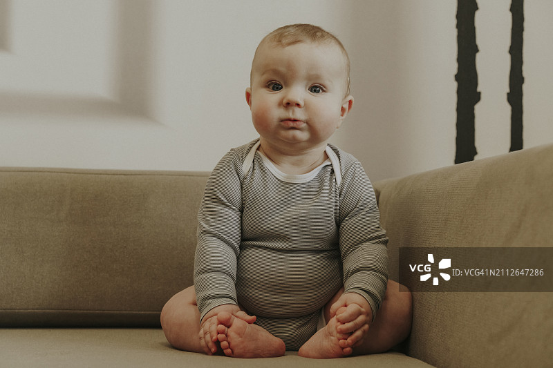 可爱的男婴坐在家里的沙发上图片素材