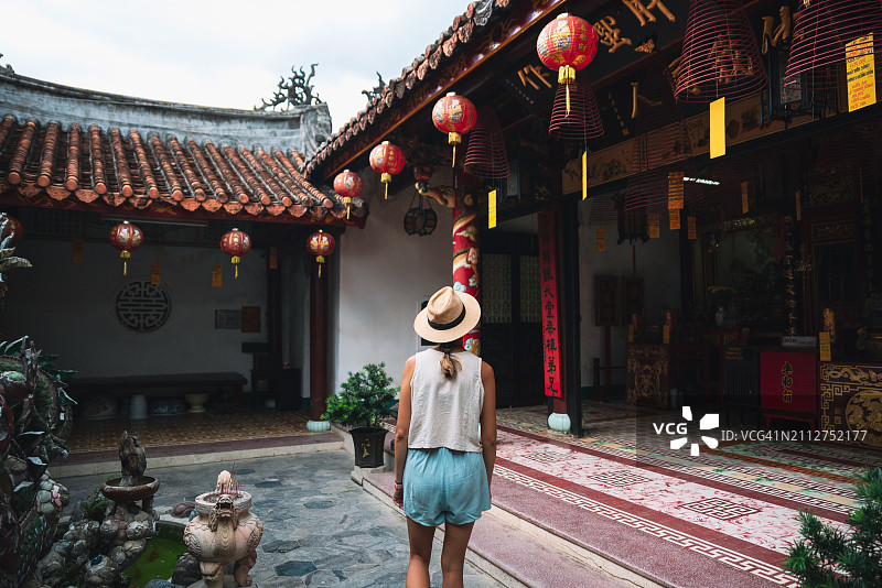 年轻女人在中国寺庙内行走图片素材