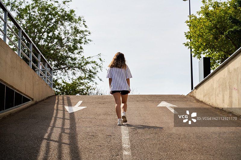 青少年在停车场边行走图片素材