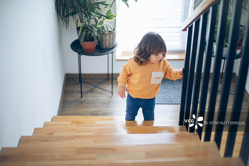 可爱的幼儿男孩自己下楼梯图片素材