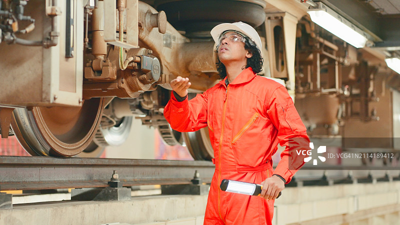 电气火车工程师使用探照灯检查电力供应图片素材