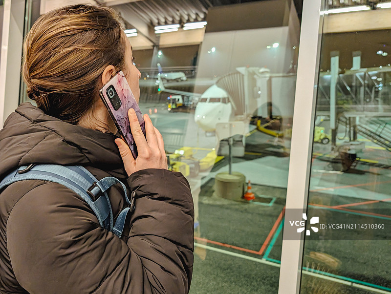 全球互联：候机时打电话的女性图片素材