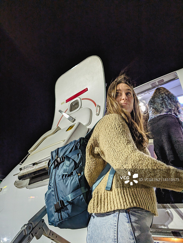 独自旅行者在夜间航班上欣赏灯光图片素材