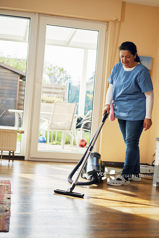 家政清洁服务-家政服务员在家吸尘图片素材