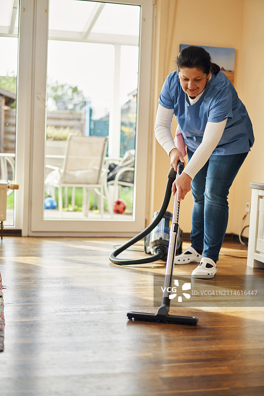 家政清洁服务-家政服务员在家吸尘图片素材