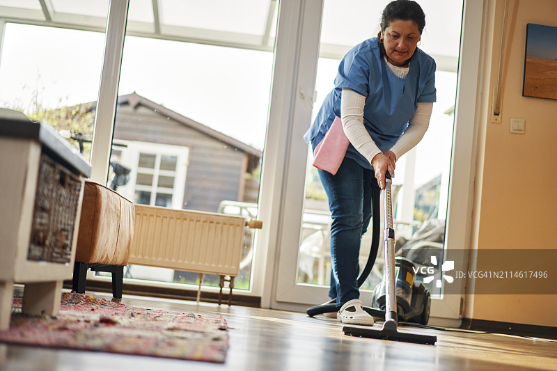 家政清洁服务-家政服务员在家吸尘图片素材