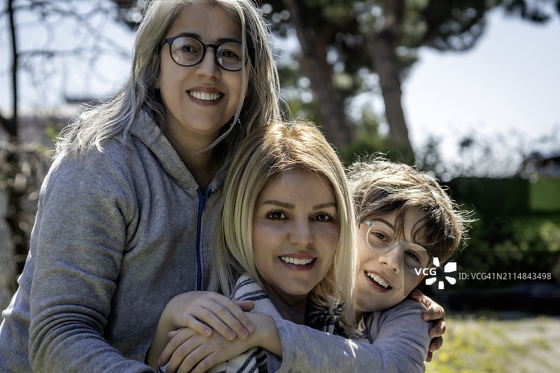 姐姐拥抱妹妹和自己的儿子图片素材