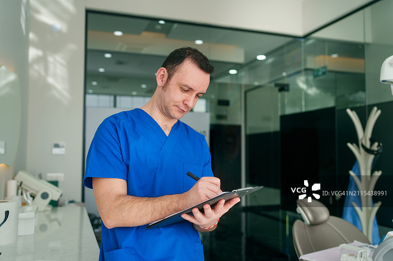 医护人员在诊所的剪贴板上书写图片素材