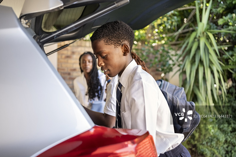 非洲兄弟姐妹将背包放入车中，准备上学图片素材