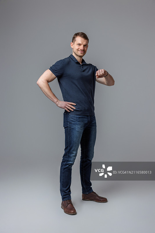 自信的成年男子佩戴智能手表站立图片素材