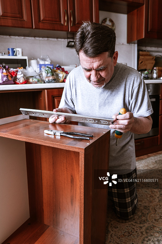在家修理厨房家具的男人图片素材