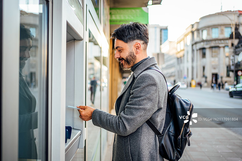 男人在城市中使用自动取款机图片素材